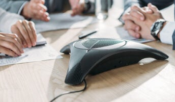Office workers using a conference phone