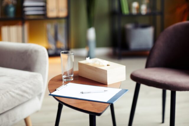 A table with tissues on in between two chairs