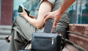 Man stealing a phone from a lady on a bench